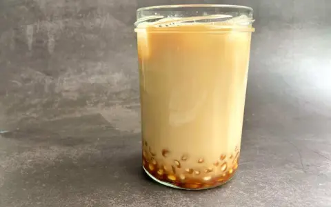 Ein Glas cremiger Milch-Tee mit Tapiokaperlen am Boden. Das ist, was Bubble Tea ausmacht!