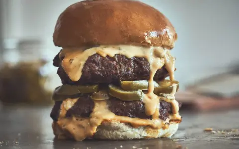 Ein saftiger Chili Cheese Burger mit zwei Patties, geschmolzener Käsesauce und Jalapeños.