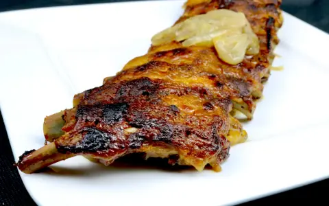 Saftige Rippchen, glasiert mit einer Honig-Senf-Marinade, serviert auf einem weißen Teller.