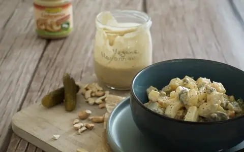 Selbstgemachte vegane Mayonnaise aus Cashews, serviert mit Kartoffelsalat und Gewürzgurken.