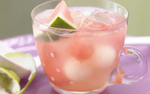 Erfrischende melonenbowle ohne alkohol in einem Glas mit Wassermelonenstücken und Eiswürfeln.