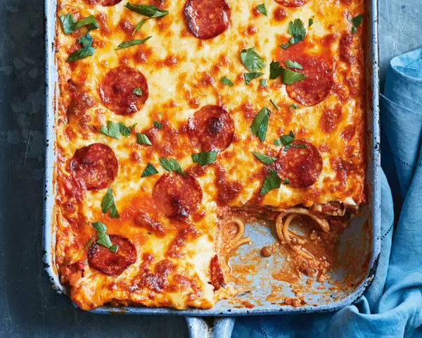 Herzhafter Spaghetti Pizza Auflauf mit geschmolzenem Käse und Pepperoni, garniert mit frischer Petersilie.