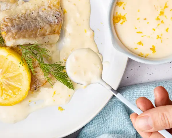 Gebratenes Fischfilet mit Zitronen-Butter-Sauce, garniert mit Dill und Zitronenscheibe.