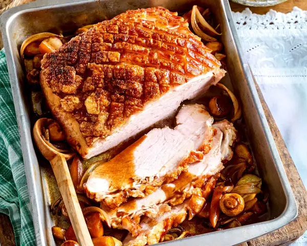 Saftiger Krustenbraten im Backofen, goldbraun und knusprig, mit Zwiebeln und Pilzen im Bratensaft. Ein Festmahl!