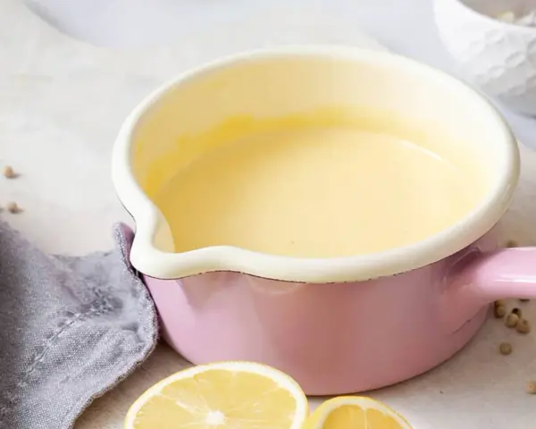 Frisch zubereitete Hollandaise in einem rosa Topf. So einfach ist es, Hollandaise selbst zu machen!