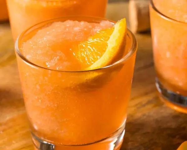 Erfrischender Aperol mit Fanta, als Slush serviert und mit einer Orangenspalte garniert. Perfekt für heiße Tage!
