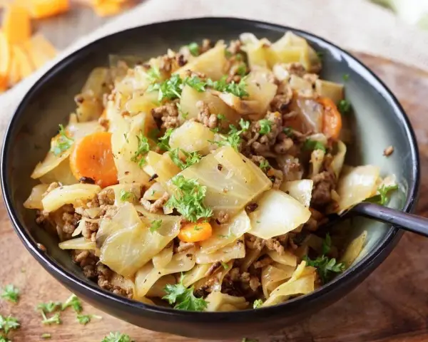 Herzhaftes Gericht aus spitzkohl mit hackfleisch und kartoffeln, garniert mit frischer Petersilie.