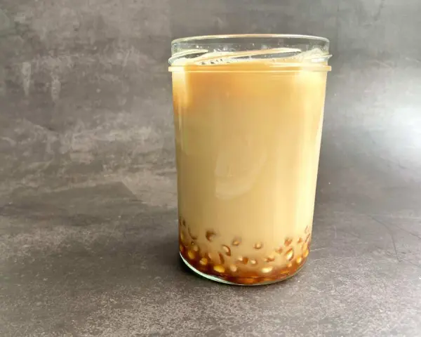 Ein Glas cremiger Milch-Tee mit Tapiokaperlen am Boden. Das ist, was Bubble Tea ausmacht!