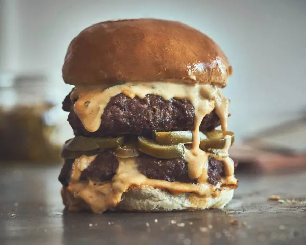 Ein saftiger Chili Cheese Burger mit zwei Patties, geschmolzener Käsesauce und Jalapeños.