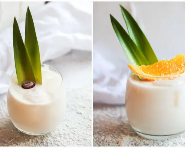 Zwei Gläser cremiger, alkoholfreier Piña Colada, garniert mit Ananasblättern und einer Orangenscheibe bzw. einer Beere.