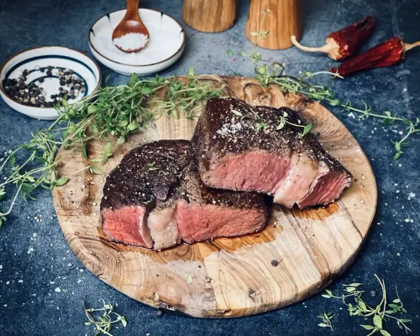 Perfekt gebratenes Rib Eye Steak, saftig und rosa, mit frischem Thymian und grobem Salz gewürzt. Ein Genuss für Fleischliebhaber.