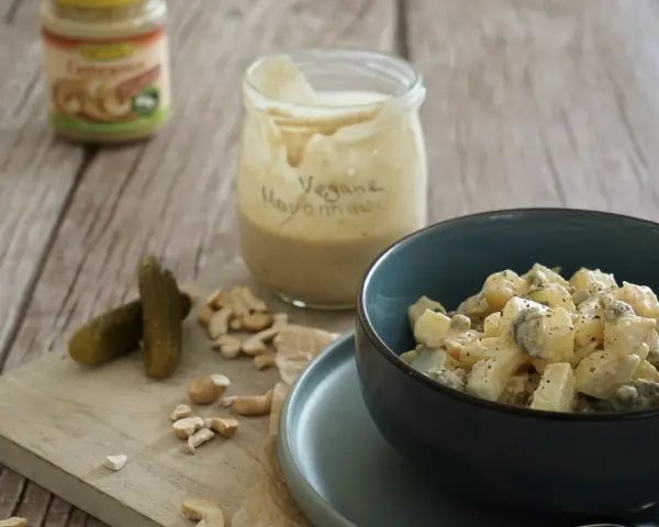 Selbstgemachte vegane Mayonnaise aus Cashews, serviert mit Kartoffelsalat und Gewürzgurken.