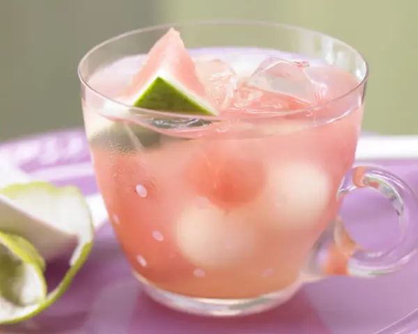 Erfrischende melonenbowle ohne alkohol in einem Glas mit Wassermelonenstücken und Eiswürfeln.