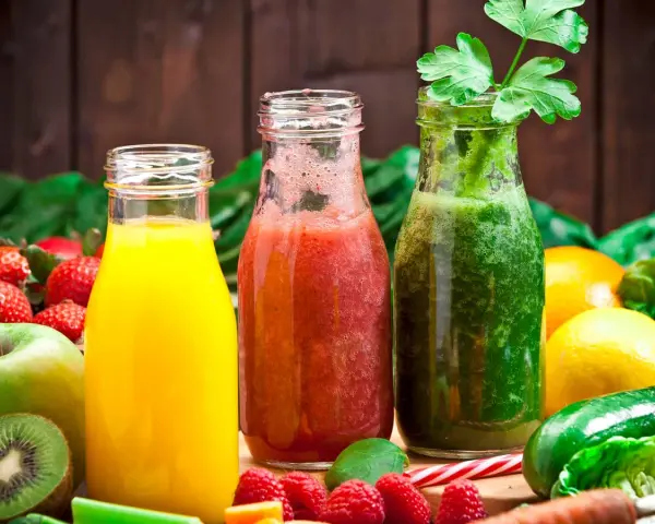 Drei Flaschen mit frisch gepresstem Saft: gelb, rot und grün. Perfekt, um Saft selber machen zu lernen und gesunde Getränke zu genießen.