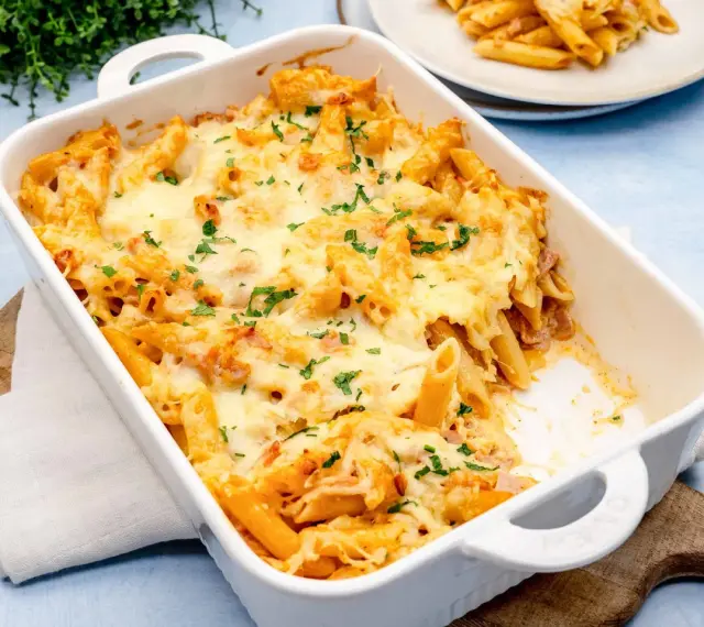 Herzhaftes Nudel Schinken Gratin mit geschmolzenem Käse und Petersilie, bereit zum Servieren.