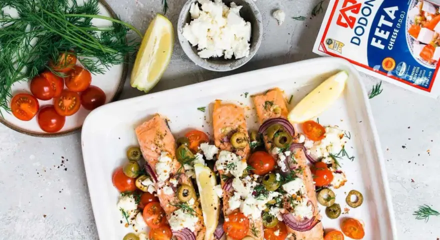 Ofenlachs mit Feta und Tomaten, garniert mit Dill und Zitrone. Ein köstliches Gericht, das nach Sommer schmeckt.