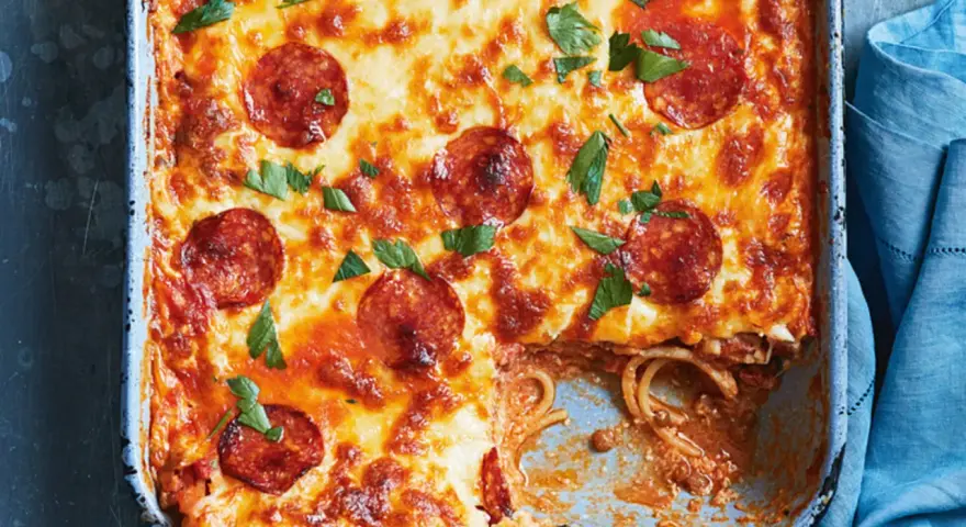 Herzhafter Spaghetti Pizza Auflauf mit geschmolzenem Käse und Pepperoni, garniert mit frischer Petersilie.