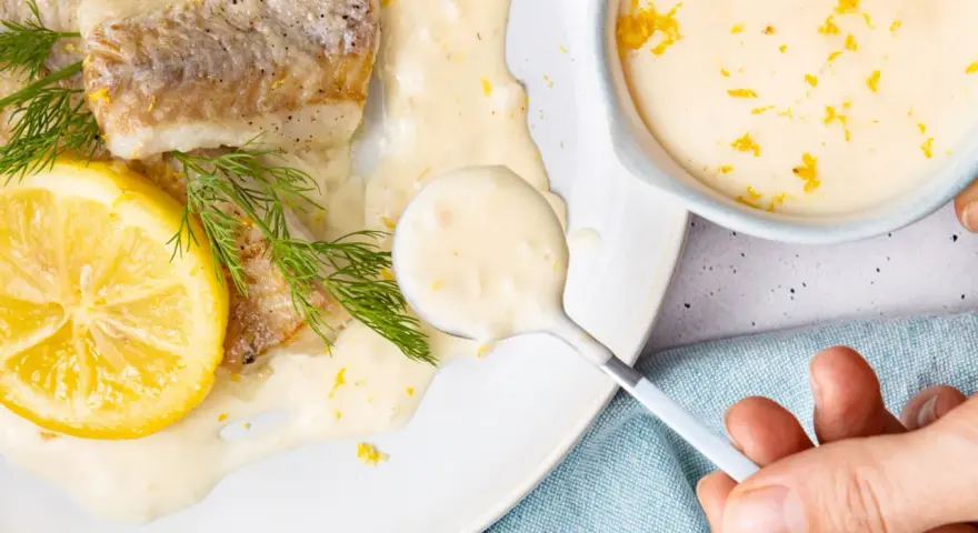 Gebratenes Fischfilet mit Zitronen-Butter-Sauce, garniert mit Dill und Zitronenscheibe.