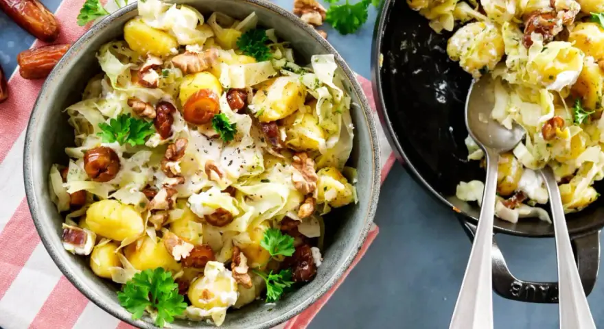 Leckeres rezept mit spitzkohl, Kartoffeln, Datteln und Walnüssen in cremiger Soße, garniert mit Petersilie.