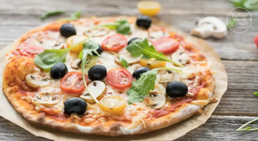 Leckerer Pizzaboden mit Joghurt, belegt mit Tomaten, Oliven und Pilzen.