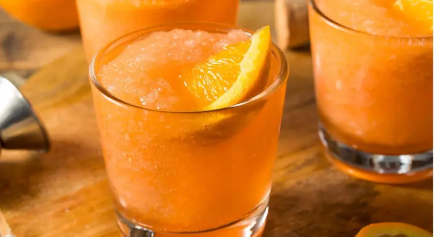 Erfrischender Aperol mit Fanta, als Slush serviert und mit einer Orangenspalte garniert. Perfekt für heiße Tage!