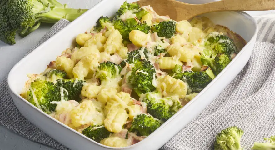 Herzhafter Brokkoli Gnocchi Auflauf mit Schinken und Käse überbacken, bereit zum Servieren.