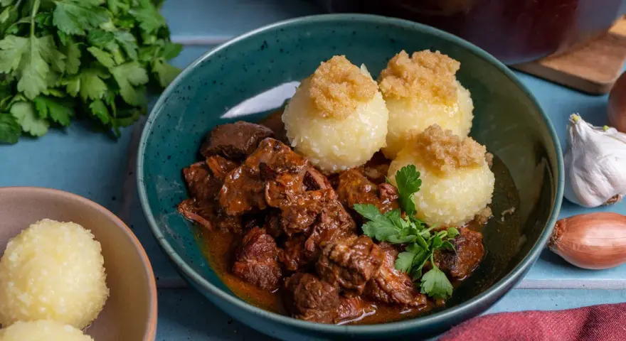 Herzhaftes Rindergulasch nach Omas Rezept, serviert mit Klößen und frischer Petersilie. Ein Klassiker, der immer schmeckt.