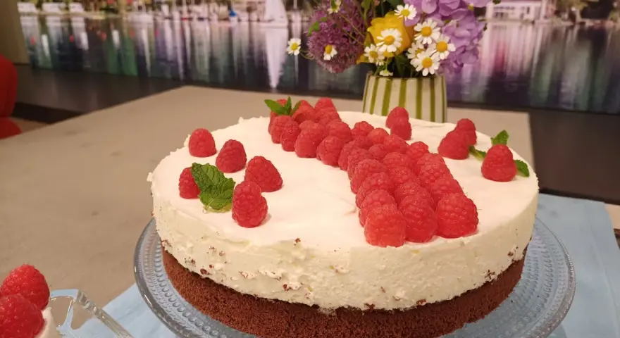 Himbeer Mascarpone Torte mit frischen Himbeeren und Minze verziert, ein Genuss für Augen und Gaumen.