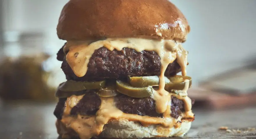Ein saftiger Chili Cheese Burger mit zwei Patties, geschmolzener Käsesauce und Jalapeños.