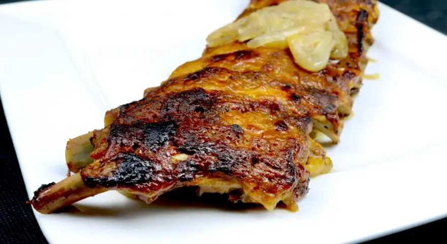 Saftige Rippchen, glasiert mit einer Honig-Senf-Marinade, serviert auf einem weißen Teller.
