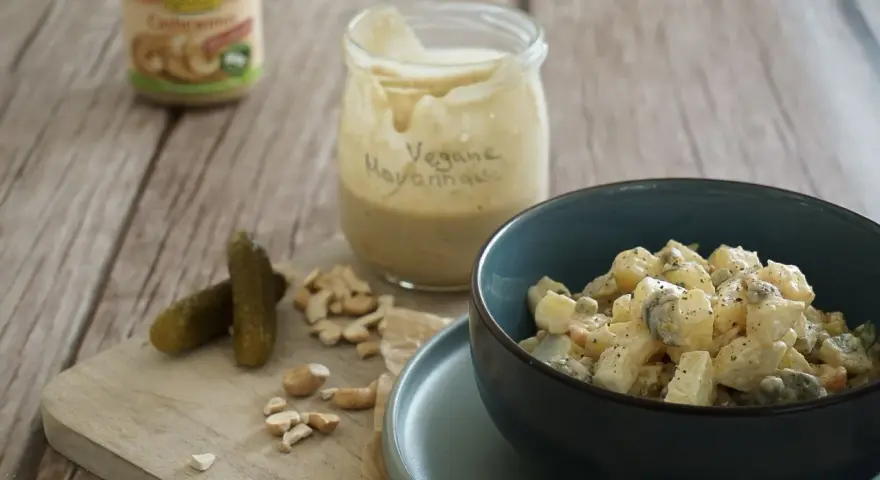 Selbstgemachte vegane Mayonnaise aus Cashews, serviert mit Kartoffelsalat und Gewürzgurken.
