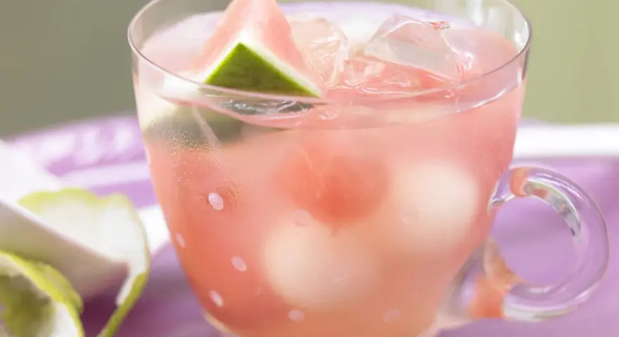 Erfrischende melonenbowle ohne alkohol in einem Glas mit Wassermelonenstücken und Eiswürfeln.