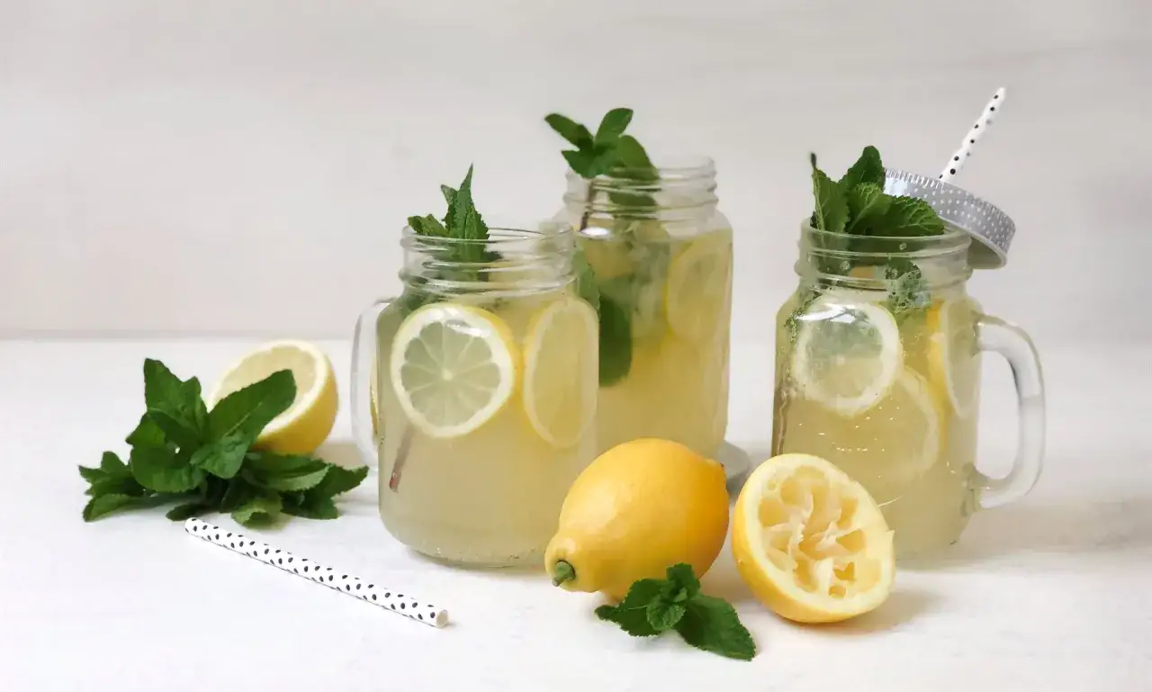 Erfrischende selbstgemachte Limonade in Einmachgl&auml;sern mit Zitronenscheiben und Minze. Perfekt f&uuml;r hei&szlig;e Tage!