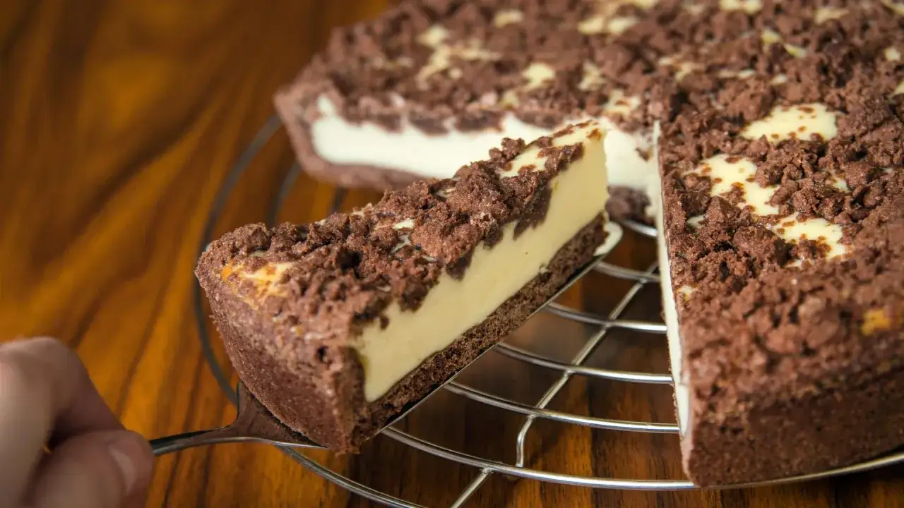 Ein Stück saftiger russischer Zupfkuchen mit Schokoladenstreuseln und cremiger Füllung wird herausgehoben.