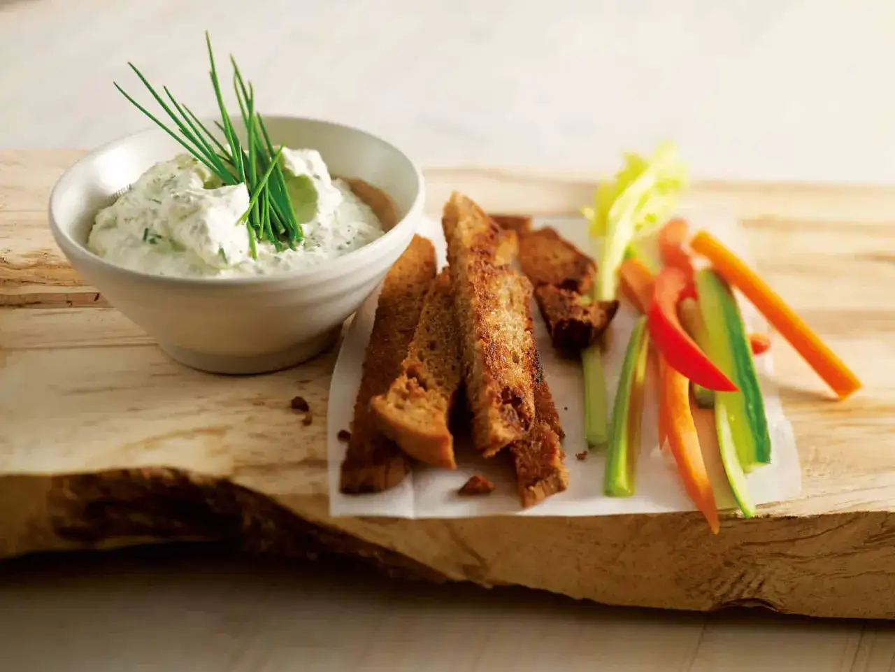 Cremiger Dip mit Kr&auml;utern, dazu knusprige Brotscheiben und Gem&uuml;sesticks &ndash; perfekt f&uuml;r Dips zum Grillen.