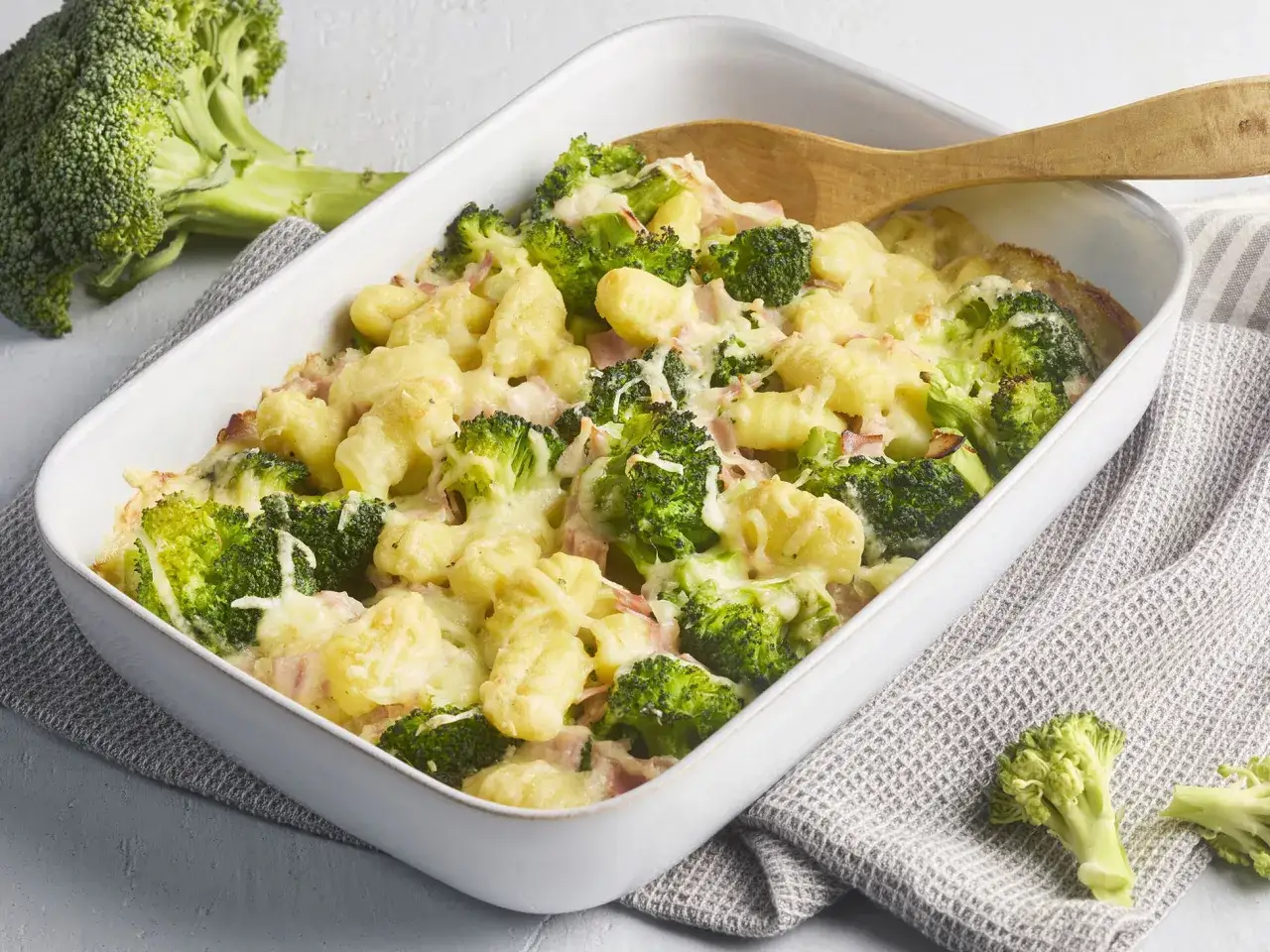 Ein herzhafter Brokkoli Gnocchi Auflauf mit Schinken und geschmolzenem Käse, bereit zum Servieren.