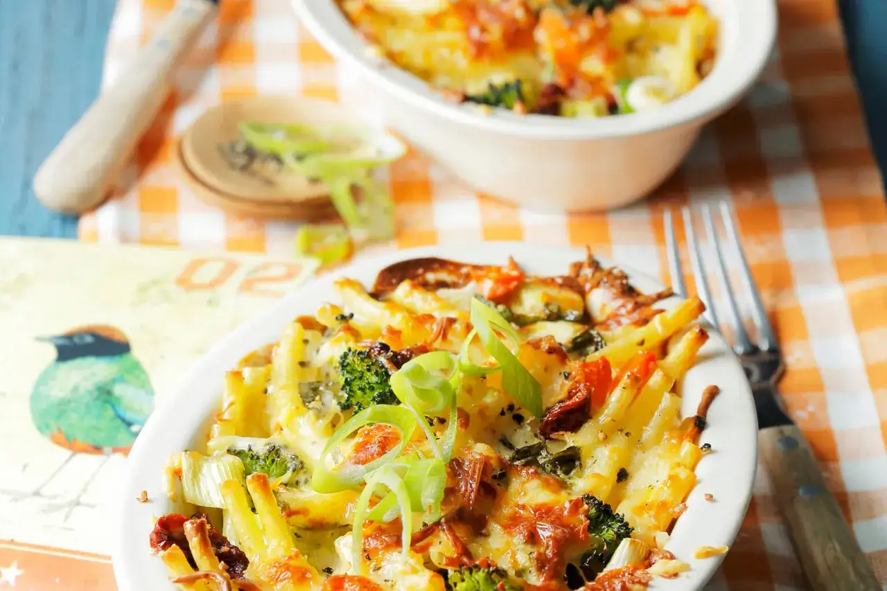 Ein köstlicher Nudelauflauf mal anders, mit viel Käse, Brokkoli und sonnengetrockneten Tomaten, garniert mit Frühlingszwiebeln.