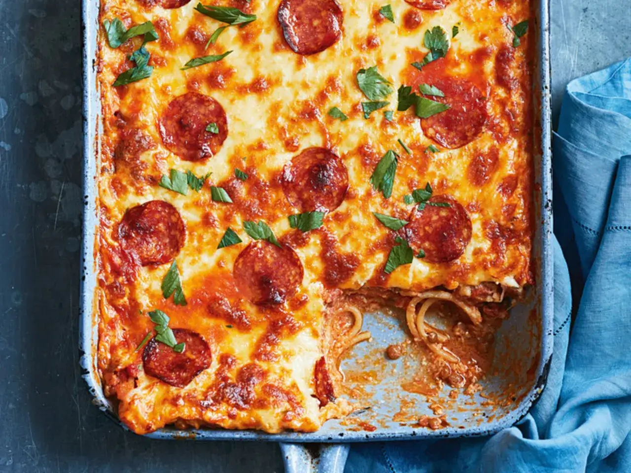 Herzhafter Spaghetti Pizza Auflauf mit geschmolzenem K&auml;se und Pepperoni, garniert mit frischer Petersilie. Ein Genuss f&uuml;r die ganze Familie!