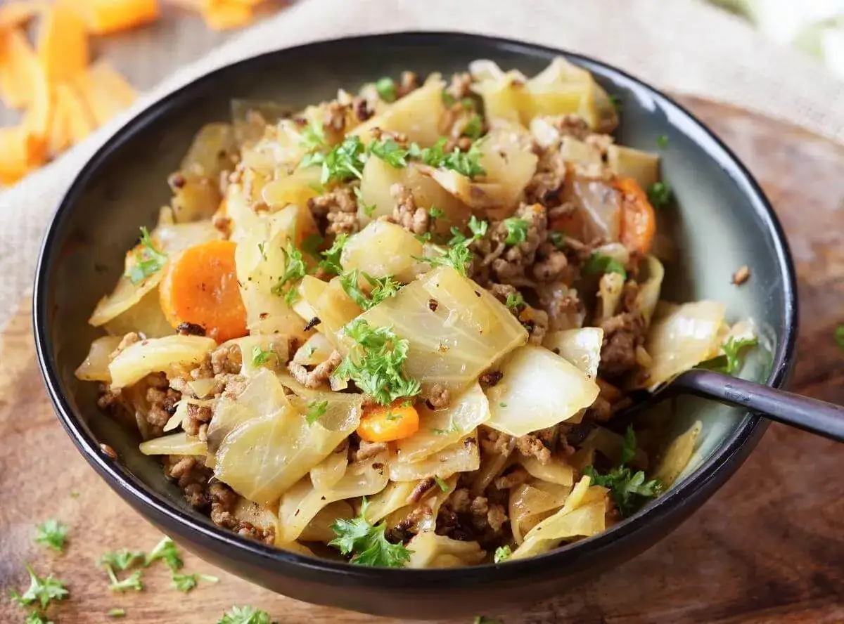 Herzhaftes Gericht aus spitzkohl mit hackfleisch und kartoffeln, garniert mit frischer Petersilie.