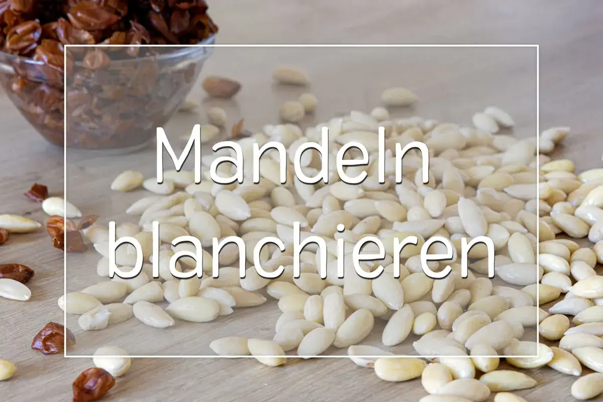 Blanchierte Mandeln liegen auf einem Holztisch. So kannst du ganz einfach mandelmehl selber machen.