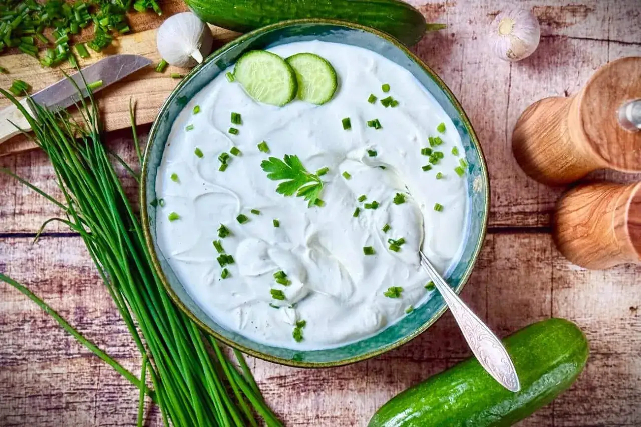 Cremige Knoblauchsauce selber machen: Frische Zutaten wie Gurke, Schnittlauch und Knoblauch liegen bereit.