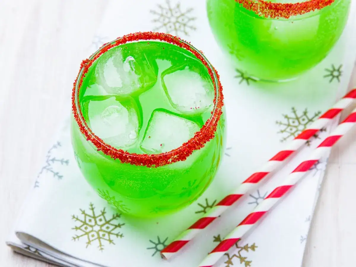 Grüner Grinch Cocktail mit Eis und rotem Rand, perfekt für das nächste Rezept.