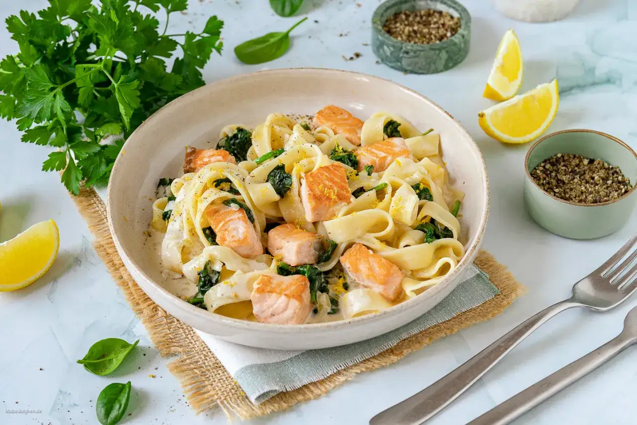 Lachs Spinat Pasta in cremiger Sauce, garniert mit Zitronenschale und frisch gemahlenem Pfeffer. Ein Genuss!