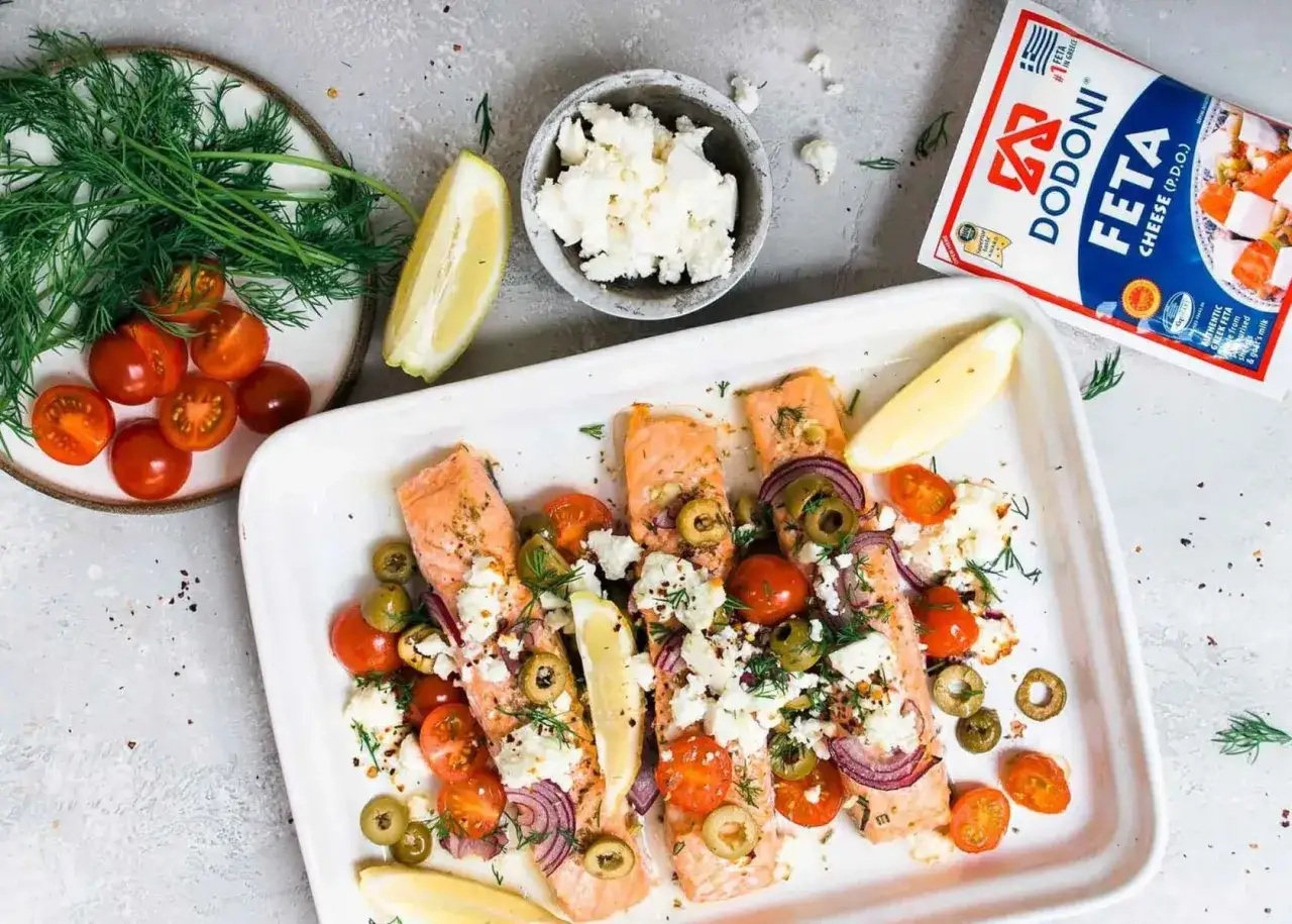 Ofenlachs mit Feta und Tomaten, garniert mit Oliven und Dill. Ein Hauch von Zitrone rundet das Gericht ab.