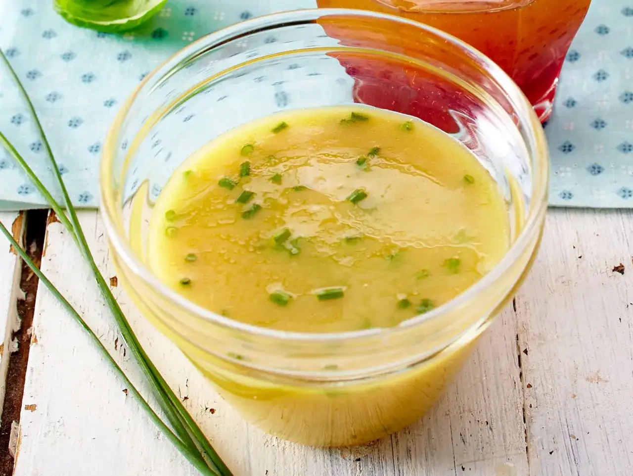 Ein Glas mit cremigem honig senf dressing, garniert mit Schnittlauch. Perfekt für Salate.