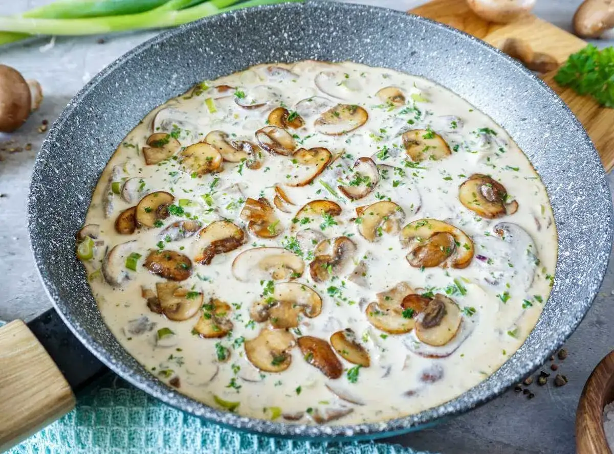 Cremige Champignon Rahmsauce mit frischer Petersilie in einer Pfanne, bereit zum Servieren.