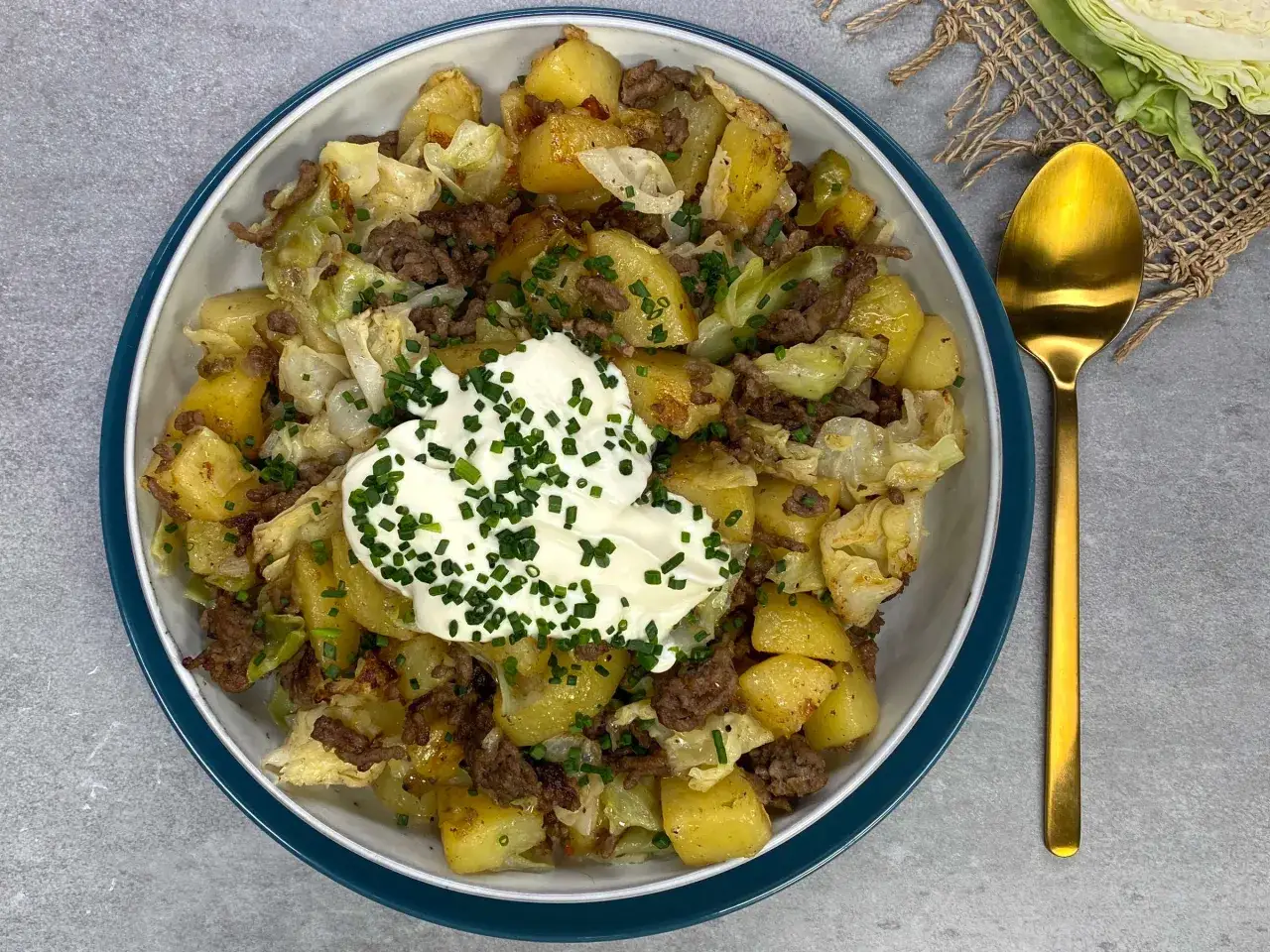 Herzhaftes Gericht mit Kartoffeln, Hackfleisch und Spitzkohl, garniert mit einem Klecks Sour Cream und Schnittlauch. Ein tolles Rezept mit Spitzkohl!