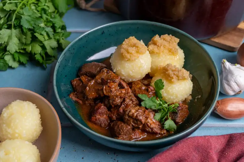 Herzhaftes Rindergulasch nach Omas Rezept, serviert mit Klößen und frischer Petersilie. Ein Klassiker, der immer schmeckt.